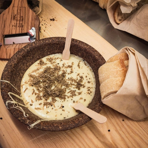 Frischer geraspelter Trüffel auf Trüffelkäsefondue mit Hobel und Baguette